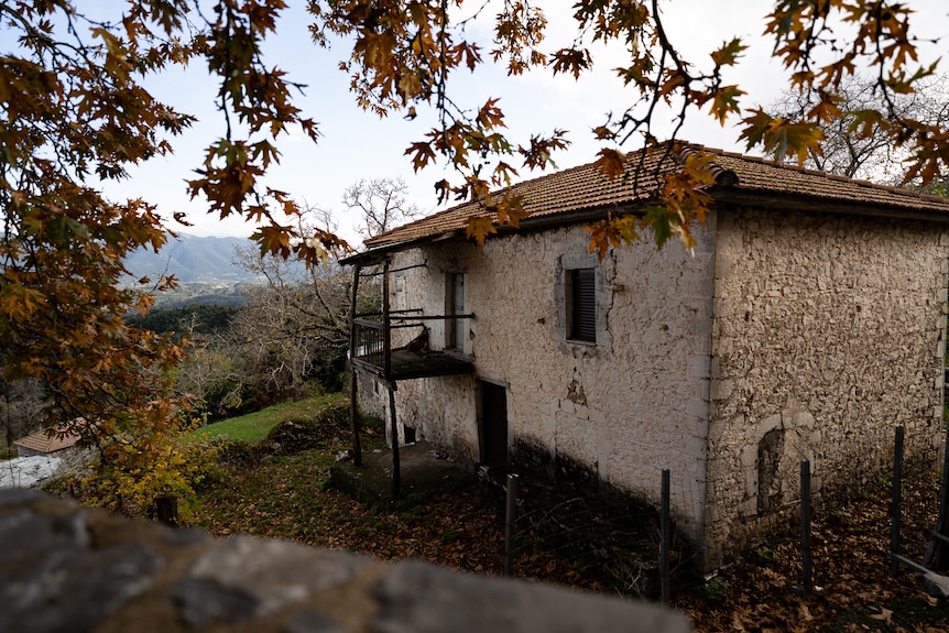 A rustic, stone building with white walls and a red tile roof.
