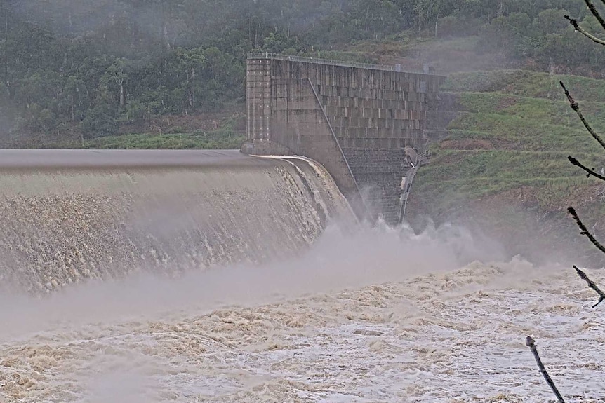 flooded dam pouring into brown water