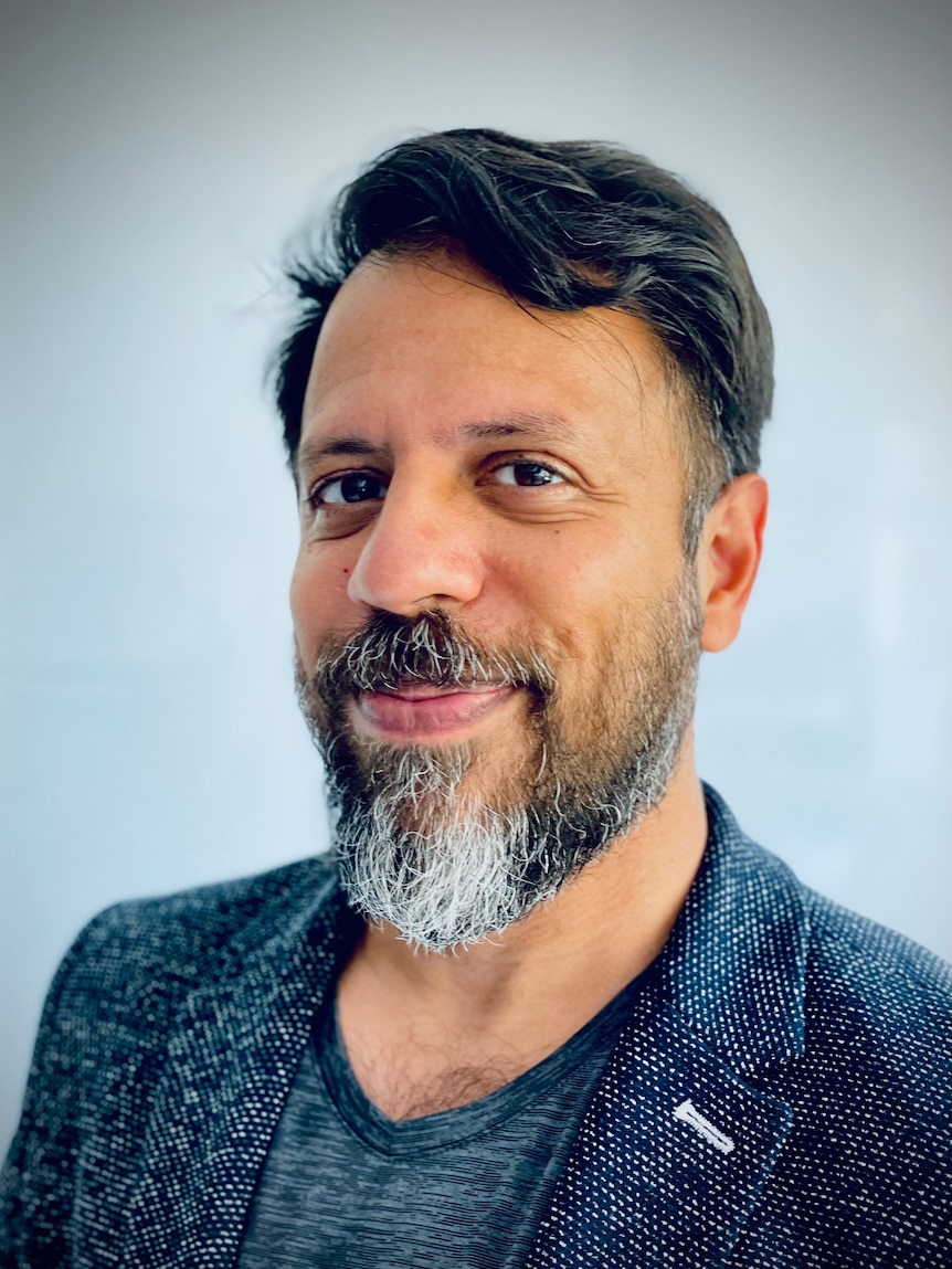 A portrait of a middle-aged man in a blazer