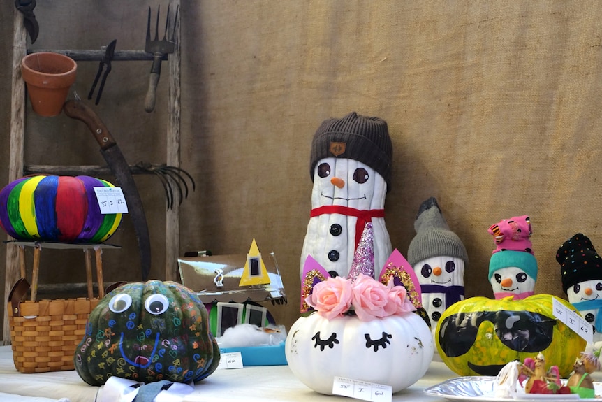 various pumpkins painted to look like a unicorn, a hot air ballon and creatures.