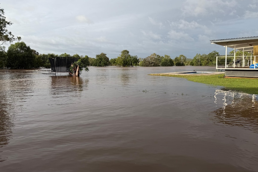 Floodwater covers the backyard of a residential property.