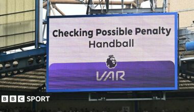 A big screen display a VAR check for a possible penalty during a Premier League match