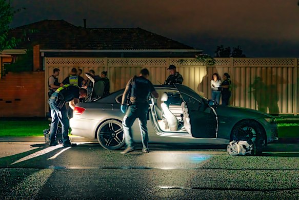 Officers search the stolen BMW and questions its occupants. 
