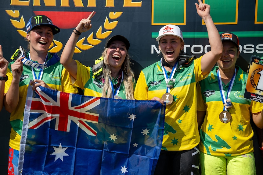 Four female Australian motocross riders standing on the podium after winning the Oceania Women's Motocross Cup.
