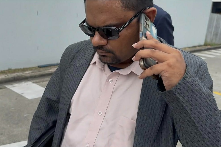 Close up shot of man talking on a phone, wearing sunglasses