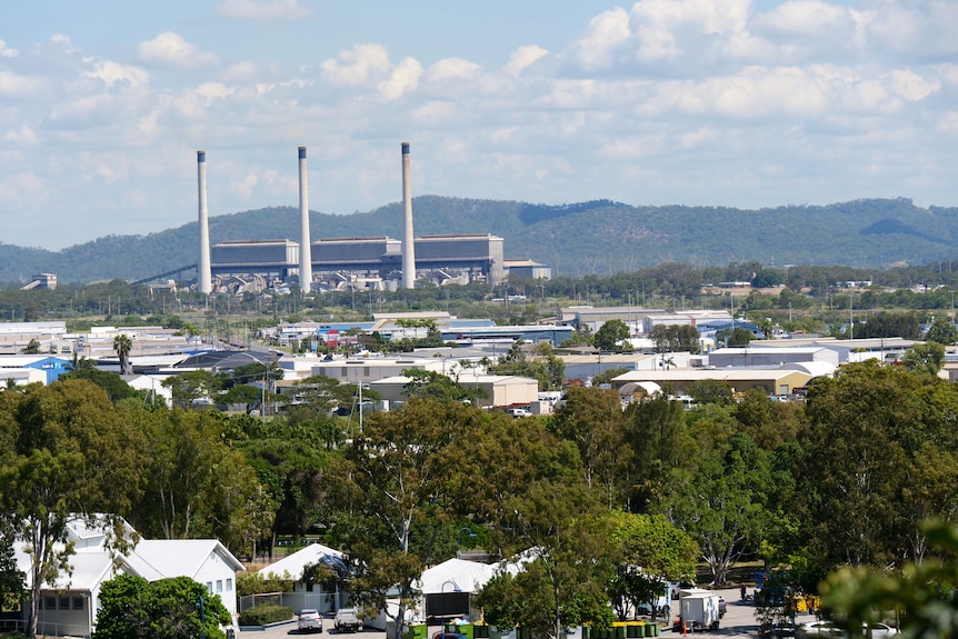 A view of the city with the power plant and mountains in the background.