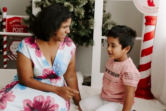 A woman and a young boy sitting and smiling. 