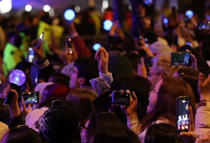 Fans of K-pop boy band BTS film the group with their mobile phones during the “BTS THE COMEBACK LIVE: ARIRANG” at Gwanghwamun Square in Seoul, Saturday. Yonhap