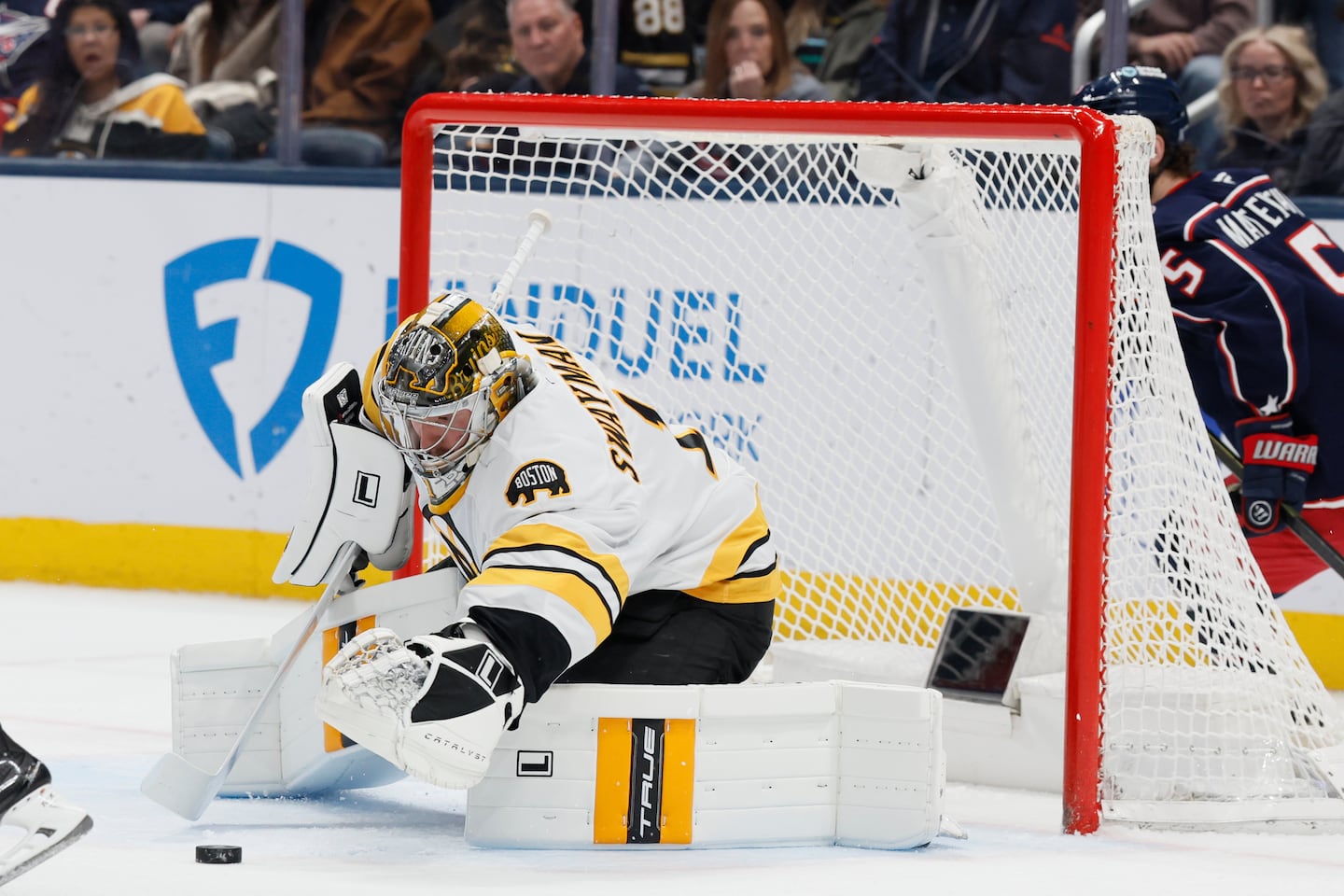 Bruins goalie Jeremy Swayman covers up the puck during the first period of Sunday's showdown against the Blue Jackets in Columbus, Ohio.