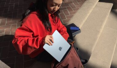 young woman putting Apple MacBook Air into a satchel