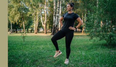 Woman doing hip airplane exercise in activewear standing in green park in the sunshine