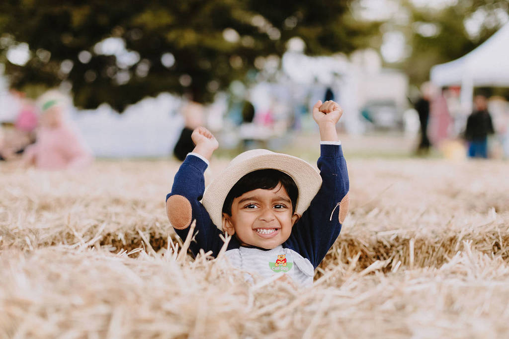 little boy popping out of a hay bale maze at Clunes Booktown Festival