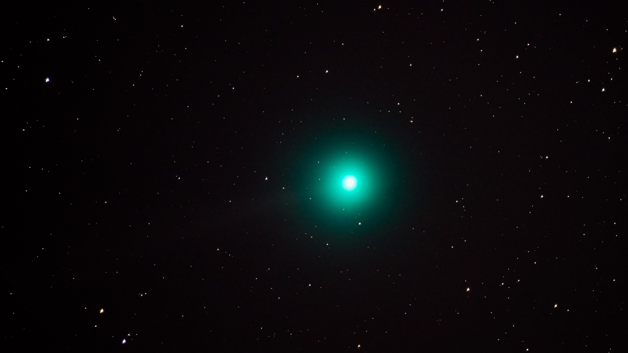 a teal green ball of light against a background of stars.
