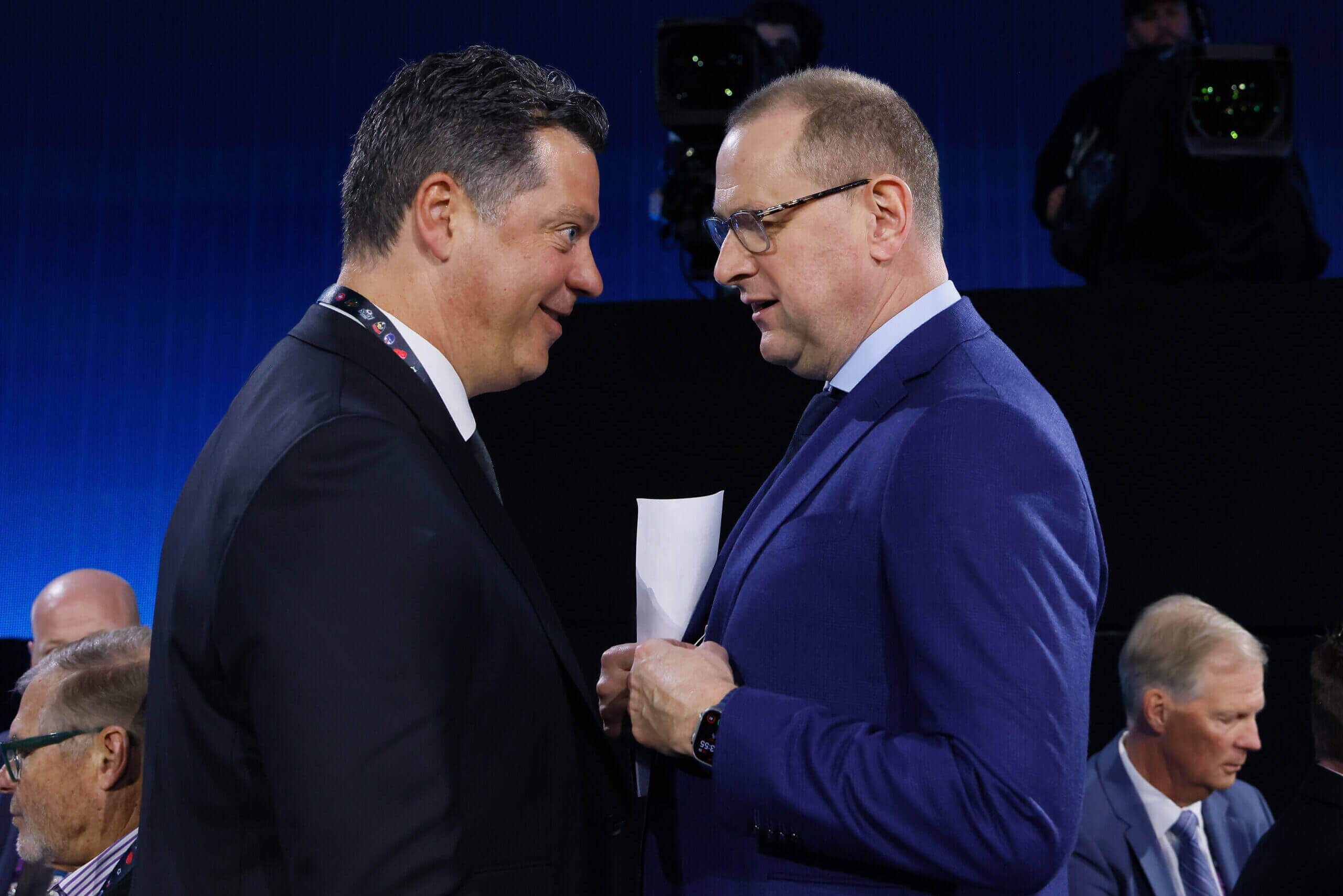 Minnesota Wild GM Bill Guerin and Brad Treliving discuss something in close quarters.