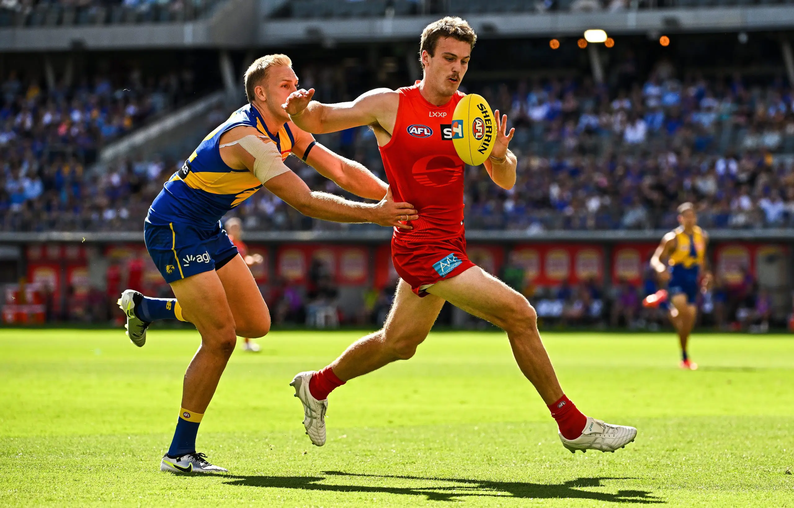 PERTH, AUSTRALIA - MARCH 16: Charlie Ballard of the Suns chases the loose ball in front of Oscar Allen of the Eagles during the 2025 AFL Round 01 match between the West Coast Eagles and the Gold Coast Suns at Optus Stadium on March 16, 2025 in Perth, Australia. (Photo by Daniel Carson/AFL Photos via Getty Images)