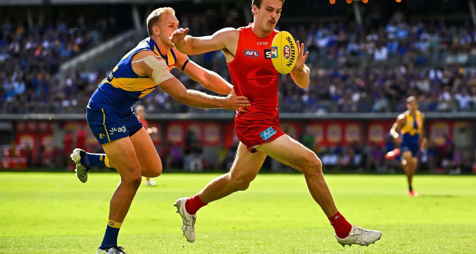PERTH, AUSTRALIA - MARCH 16: Charlie Ballard of the Suns chases the loose ball in front of Oscar Allen of the Eagles during the 2025 AFL Round 01 match between the West Coast Eagles and the Gold Coast Suns at Optus Stadium on March 16, 2025 in Perth, Australia. (Photo by Daniel Carson/AFL Photos via Getty Images)