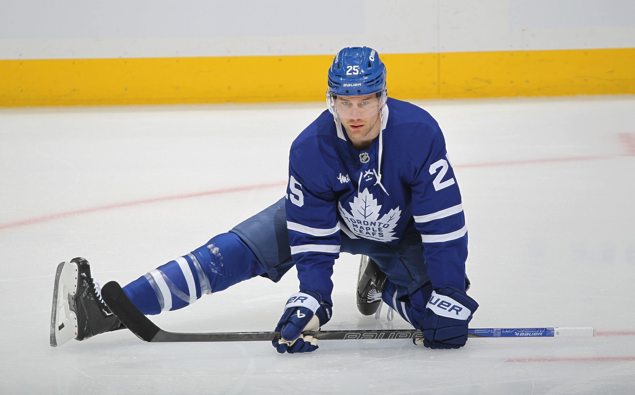 Brandon Carlo stretches a leg on the ice during Leafs warmups.