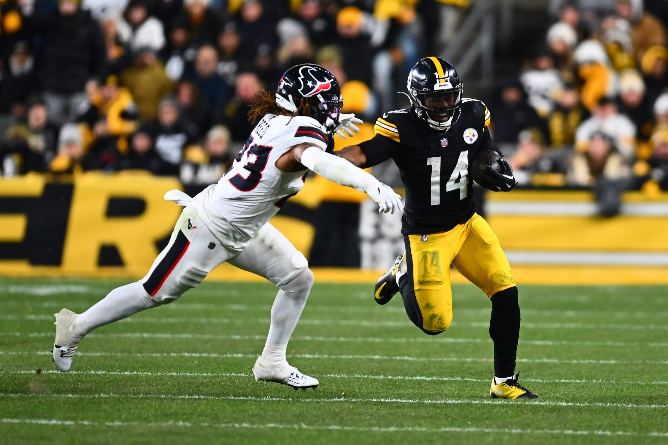 Kenneth Gainwell #14 of the Pittsburgh Steelers stiff arms Jaylen Reed #23 of the Houston Texans