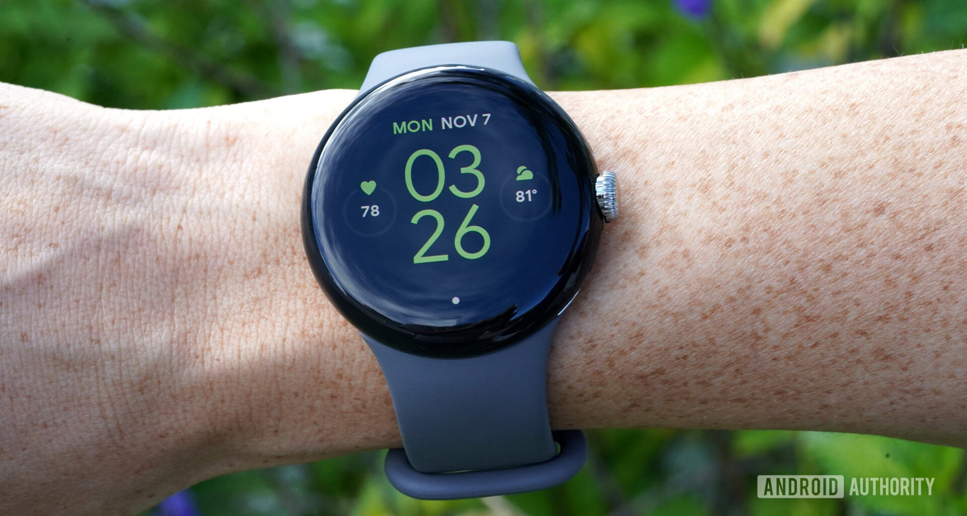 A Google Pixel Watch on a user's wrist displays the watch face.