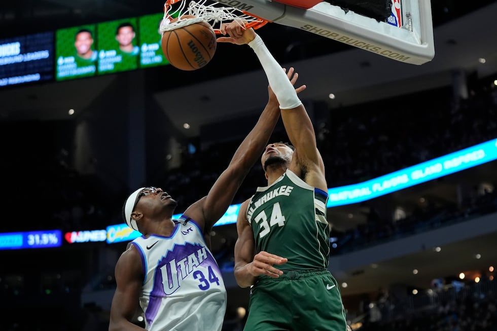 Milwaukee Bucks' Giannis Antetokounmpo, right, dunks over Utah Jazz's Oscar Tshiebwe, left,...