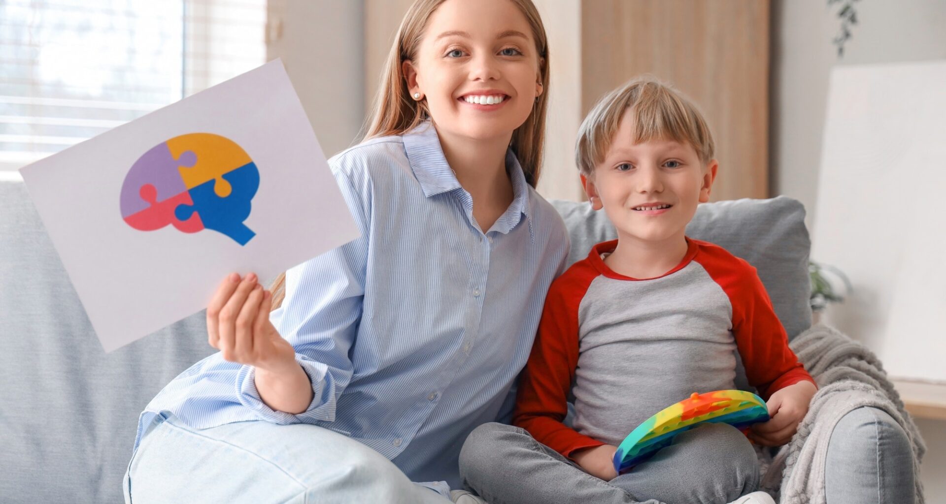 Female psychologist with little boy playing in office.