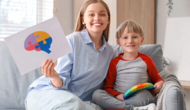 Female psychologist with little boy playing in office.