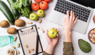 Woman workspace with healthy food. Female hands writing in the notepad words