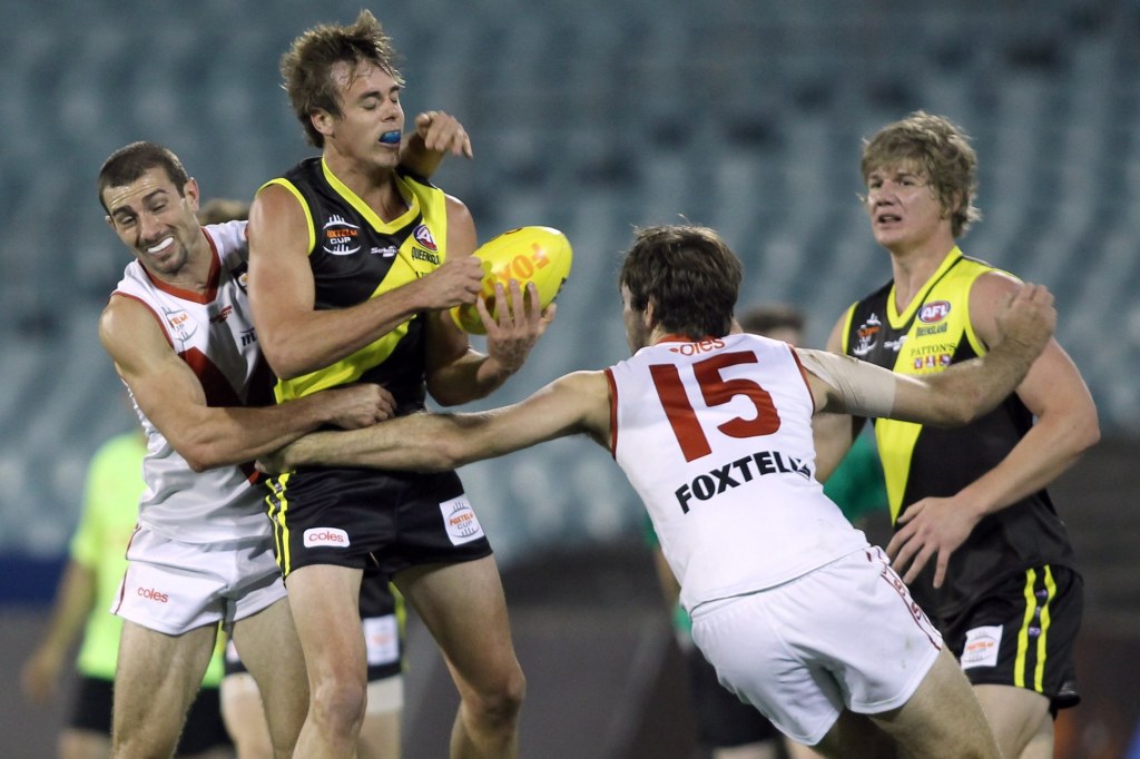 Leigh Ryswyk and David Hill of North Adelaide tackles Mathew Clarke
