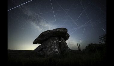 Satellites are pictured leaving long 'trails' in the night sky in a composite image featuring the Milky Way hanging over a stone monument.