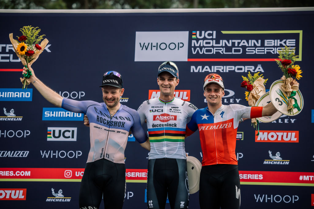 MAIRIPORA, BRAZIL - APRIL 13: L-R) second place Luca Schwarzbauer of Germany, first place Samuel Gaze of New Zeland, third place Martin Kossmann Vidaurre of Chile celebrate under the podium during the UCI Mountain Bike World Cup Mairipora Cross Country Short Track XCC Elite on April 13, 2024 in Mairipora, Brasil. (Photo by Piotr Staron/Getty Images)