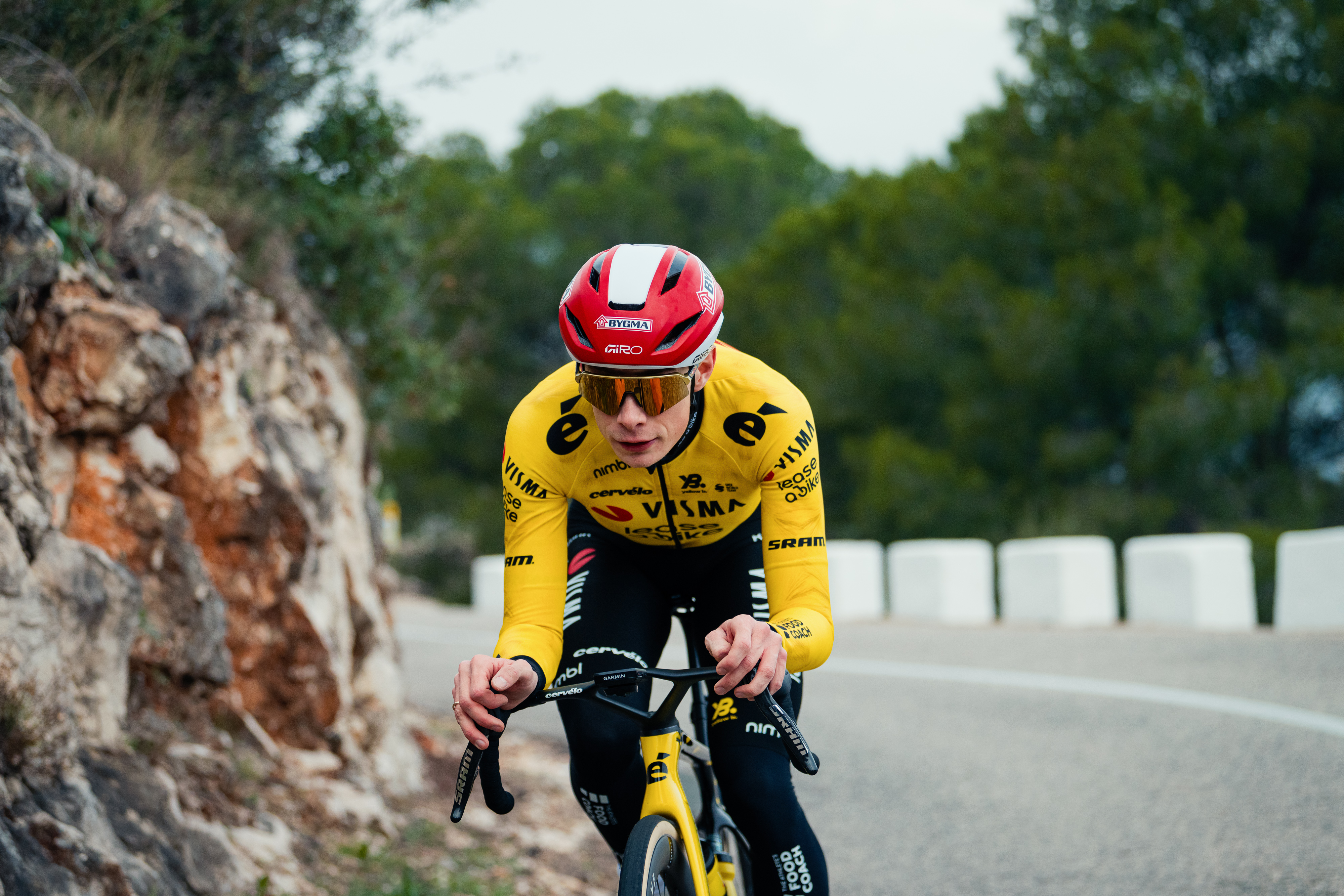 Jonas Vingegaard in a red helmet riding on a mountain road