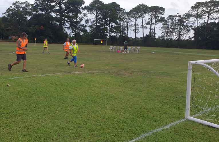 Liz lining up a shot for goal around Jeff and Shirley's defence.