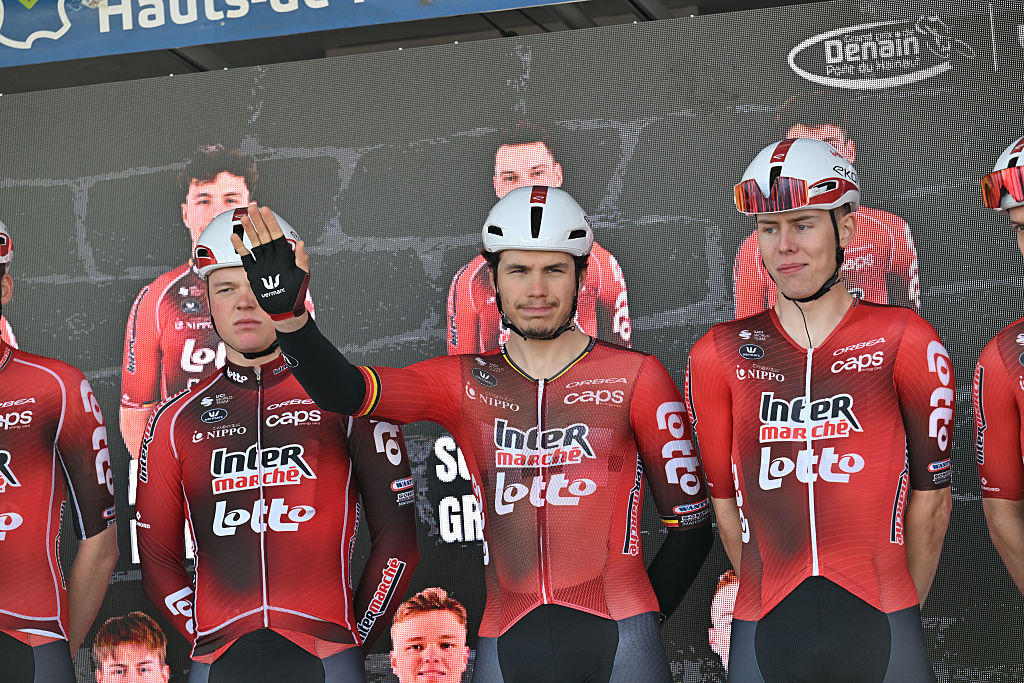 Arnaud De Lie waves to fans from the podium at the GP de Denain