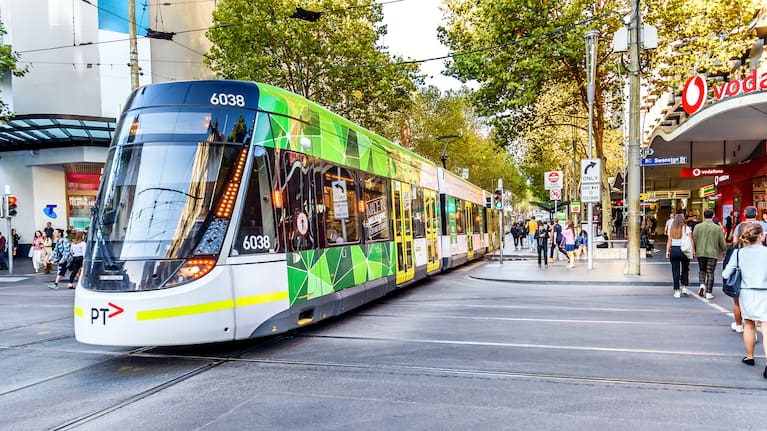 A Melbourne city tram is crossing Swanston Street into the Bourke Street Mall