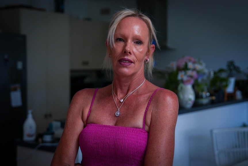 A blonde woman wearing a pink top