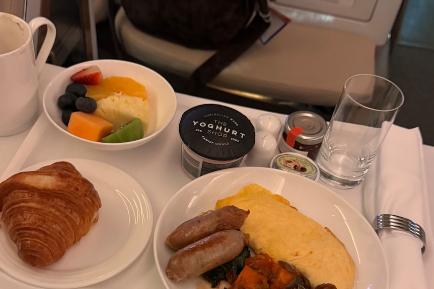 Food, including yogurt and sausages, on a tray