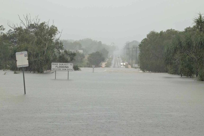 A rural road is submerged underneath floodwaters.