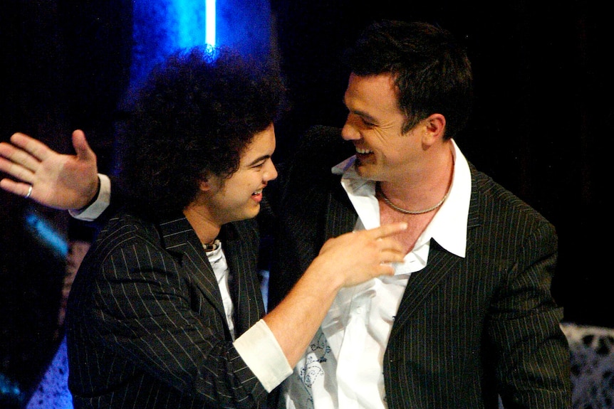 Guy Sebastian and Shannon Noll turn towards each other before an embrace.