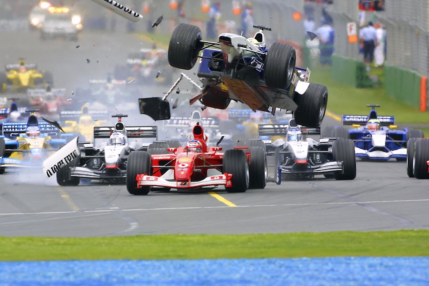 F1 car in the air, going over the top of other car others at the start of a race