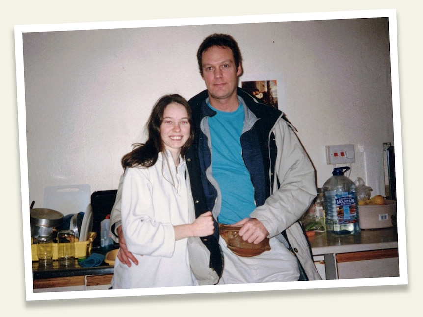 A young woman in a white shirt and a man in a blue shirt with a white jacket standing together.
