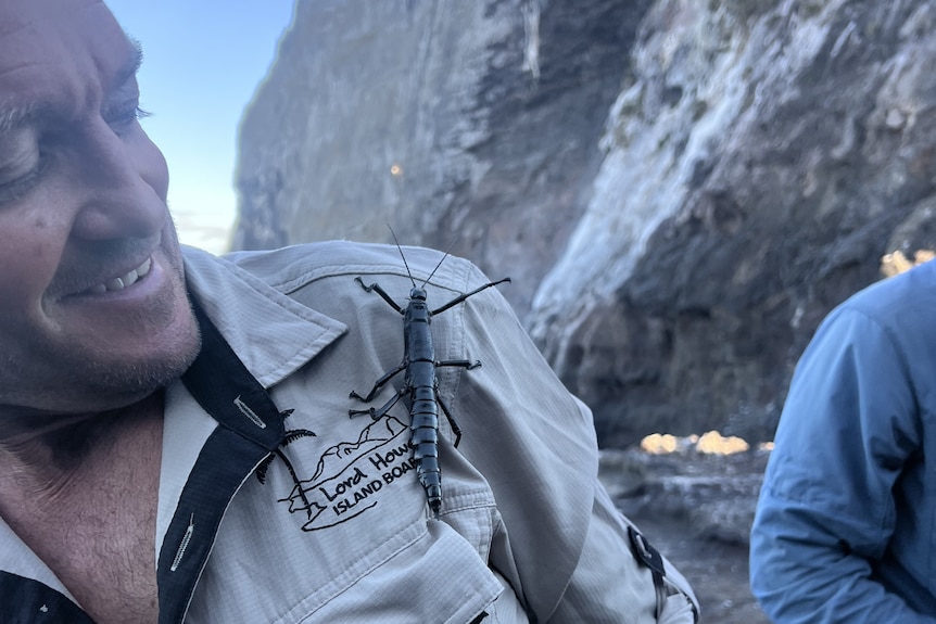 man in Lord Howe Island Board uniform with stick insect on shoulder