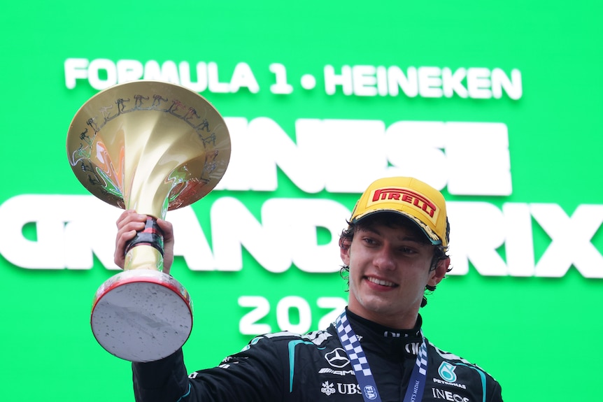 Race winner Andrea Kimi Antonelli of Italy and Mercedes holding the trophy on the podium, smiling