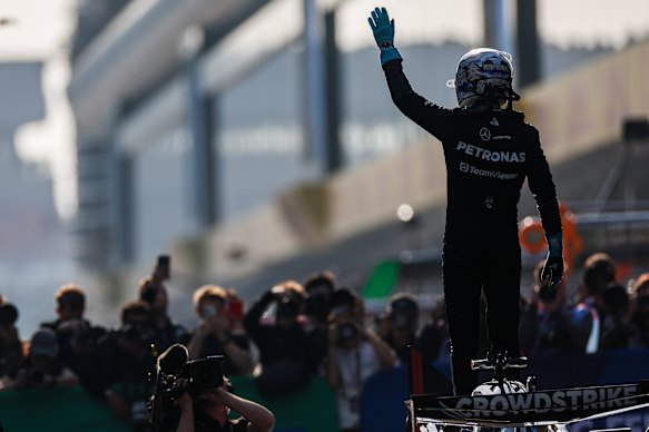 George Russell salutes the crowd.