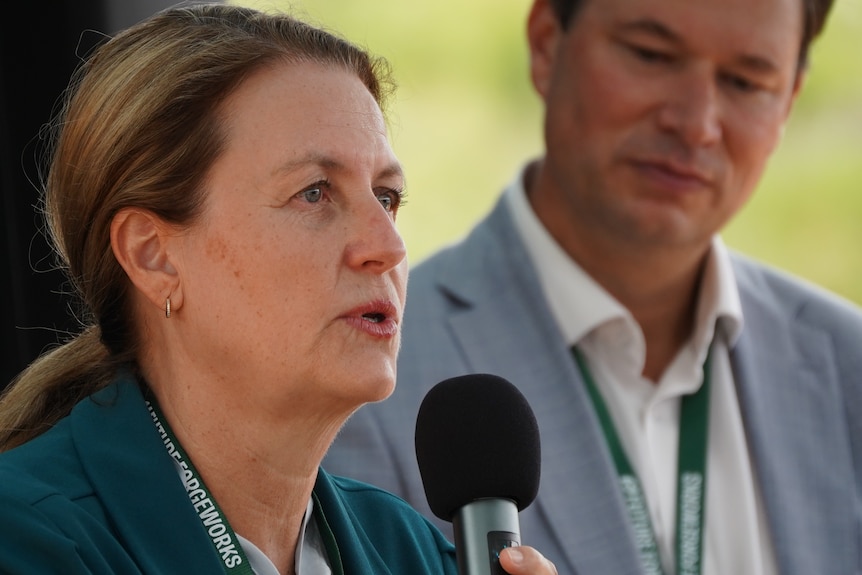 Middle aged lady talking into a microphone