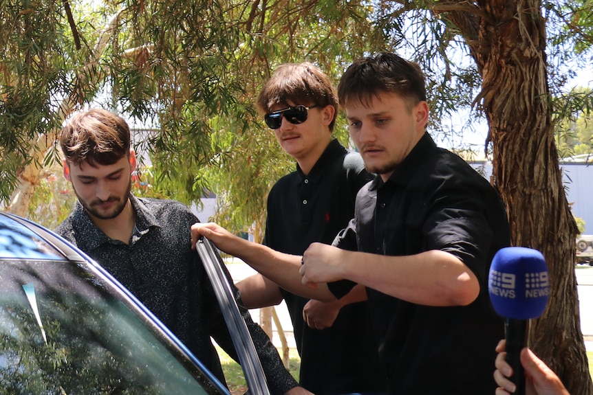 A man is bundled into a car 
