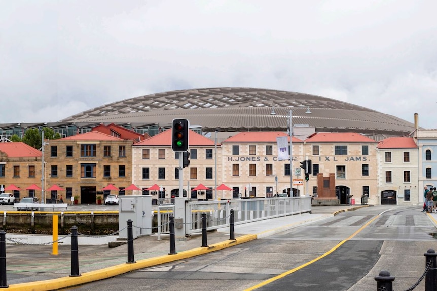 A render of the proposed Macquarie Point stadium showing a rounded roof behind heritage buildings on Evans Street Hobart