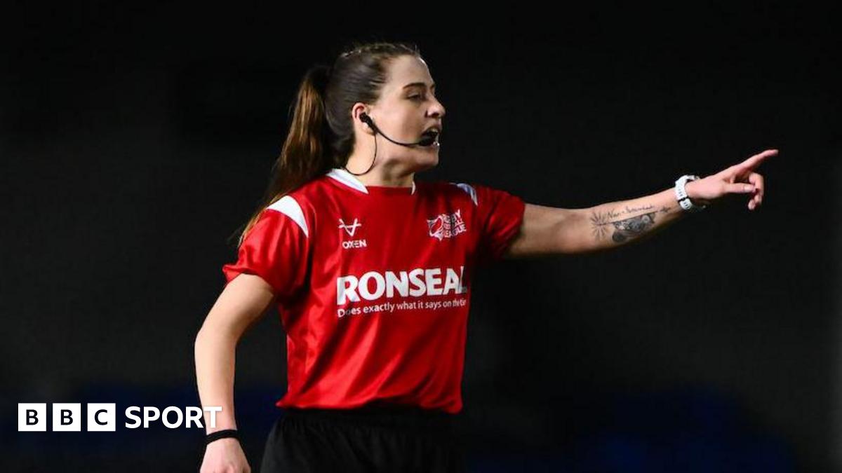 Referee Tara Jones speaking into her microphone attached to her ear while pointing towards a player while in charge of London Broncos v Widnes Vikings.