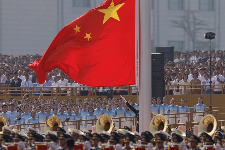 A big Chinese flag in front of a crowd