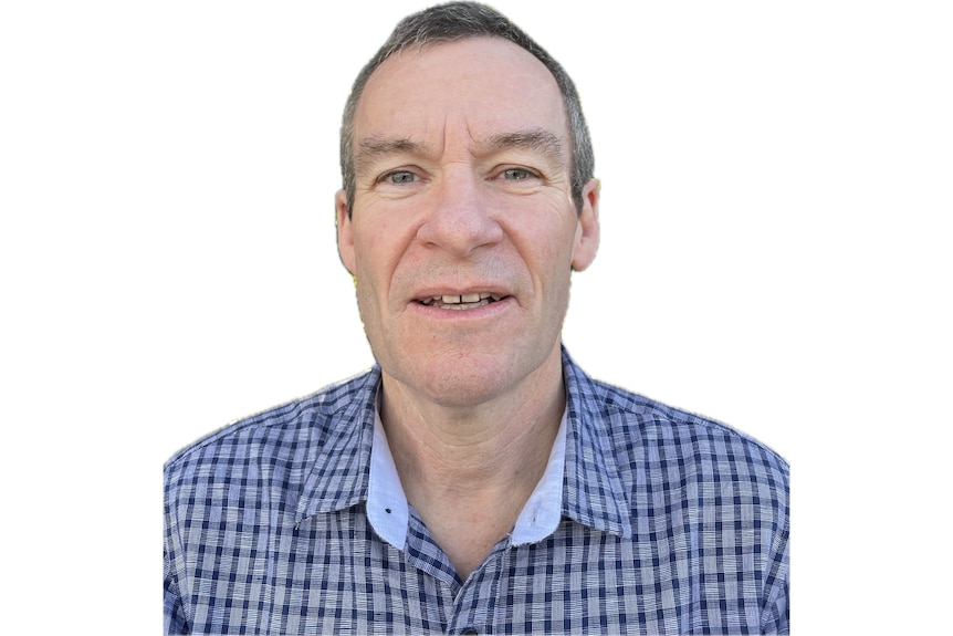A man in a checkered shirt in a white background looking at the camera