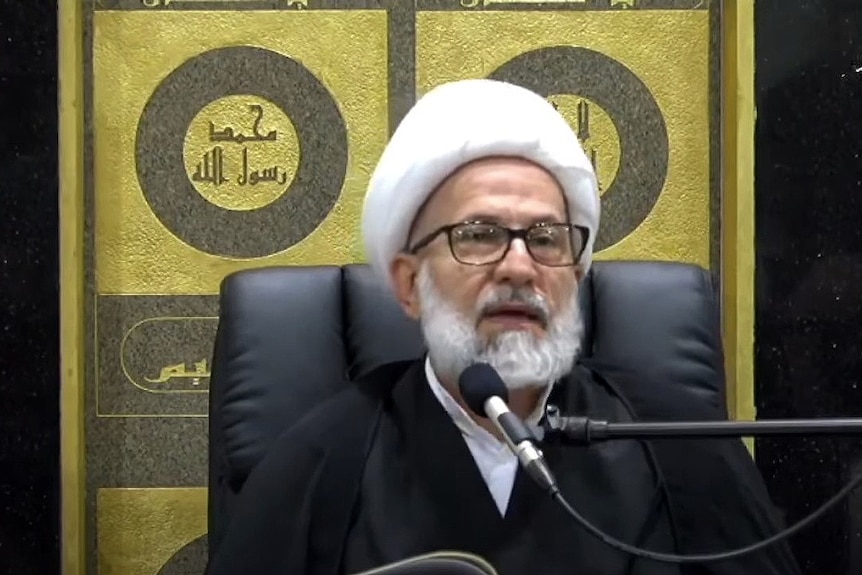 Sheik Youssef Nabha from the Masjid Arrahman mosque in Kingsgrove sits behind a microphone delivering a speech